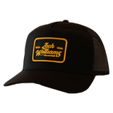 Black trucker hat with a yellow ’Jack Williams’ patch on the front.