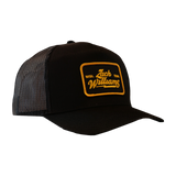 Black trucker-style cap with a yellow and orange ’Zach Williams’ patch on the front.