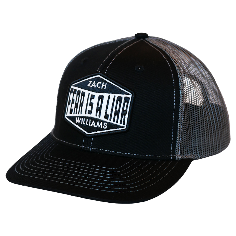 Black and gray trucker-style baseball cap with ’ZACH WILLIAMS’ text in a hexagonal logo on the front panel.