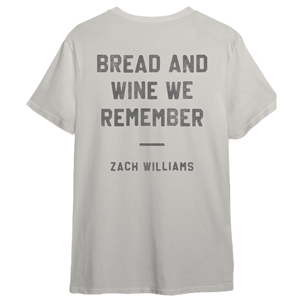 Light gray t-shirt with text ’BREAD AND WINE WE REMEMBER’ and ’ZACH WILLIAMS’ printed on it.