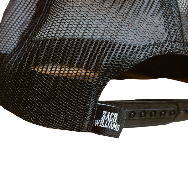 Black mesh trucker-style cap with a ’Zach Williams’ label on the adjustable strap.