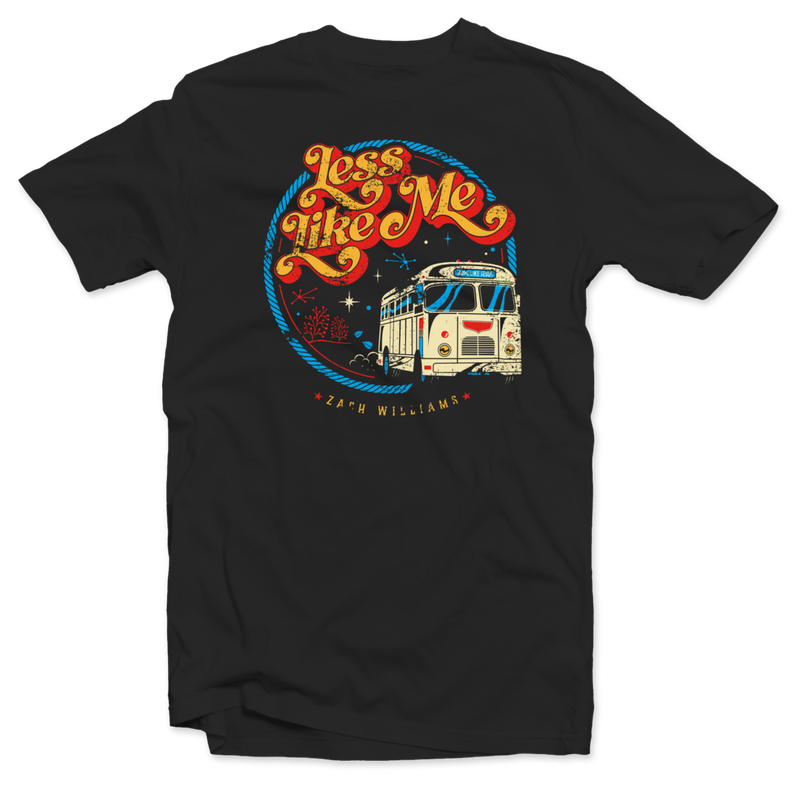 Black t-shirt featuring a colorful retro-style graphic design with the text ’Less Like Me’ and an illustration of a vintage RV.